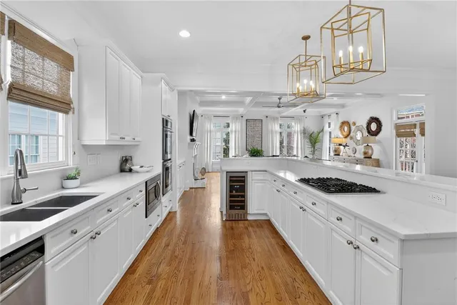 a large kitchen with stainless steel appliances granite countertop a lot of counter space and wooden floors