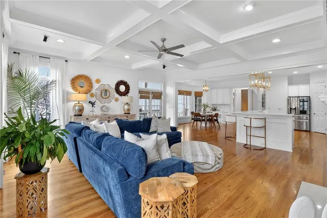 a living room with furniture kitchen view and a large window