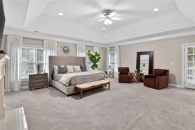 a spacious bedroom with a bed a couch and a chandelier
