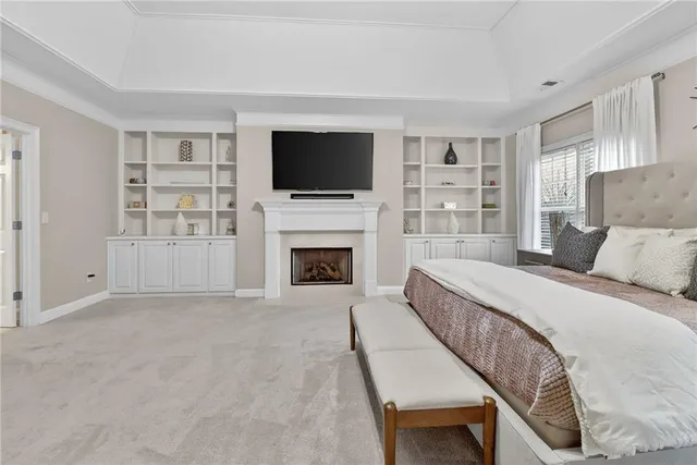 a spacious bedroom with a bed and a flat screen tv