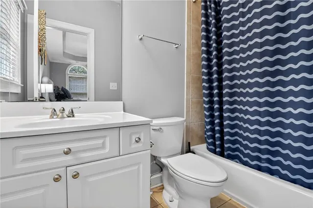 a bathroom with a granite countertop toilet a sink and a mirror