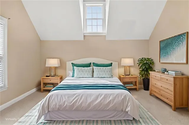 a bedroom with a bed and a potted plant on the dresser