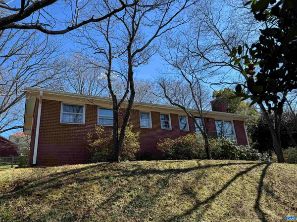 a front view of a house with yard and trees