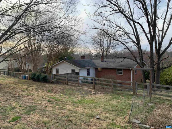 a view of a house with a yard and large tree