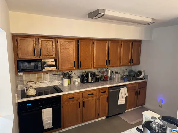 a kitchen with a sink a stove cabinets and counter space