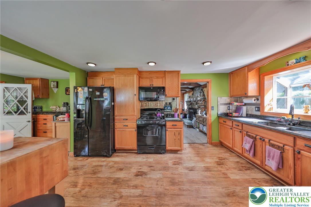 331 Cranberry Creek Road Cresco, PA 18326 - Photo 13 of 95 A well-lit kitchen with natural wood cabinetry and resilient flooring opens to a cozy living space.