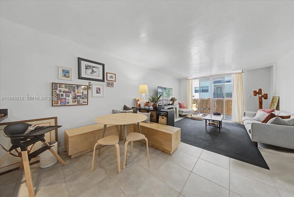 a living room with couches and a dining table with rug