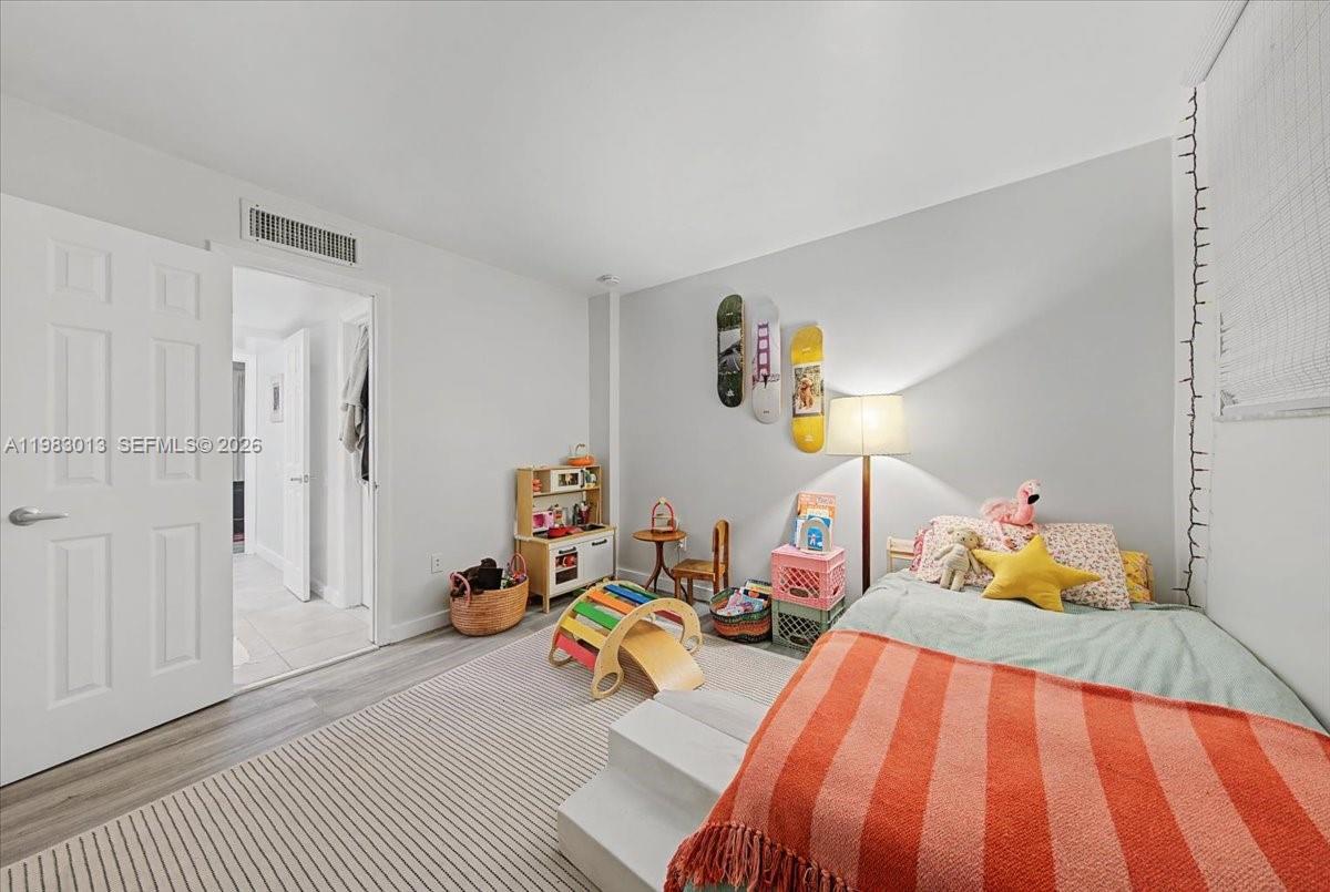 777 Northeast 62nd Street, Unit C211 Miami, FL 33138 - Photo 11 of 22 a bedroom with a bed and wooden floor