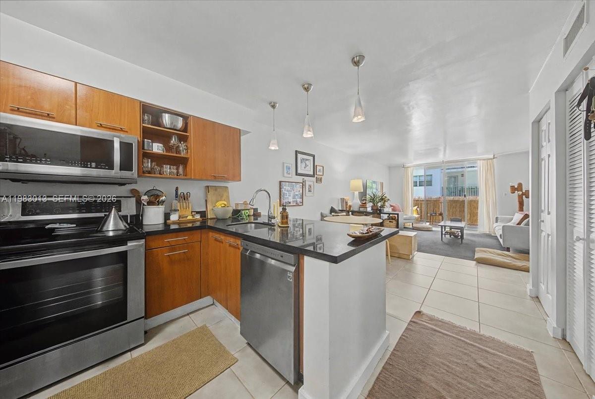 777 Northeast 62nd Street, Unit C211 Miami, FL 33138 - Photo 6 of 22 a kitchen with stainless steel appliances granite countertop a stove and a sink