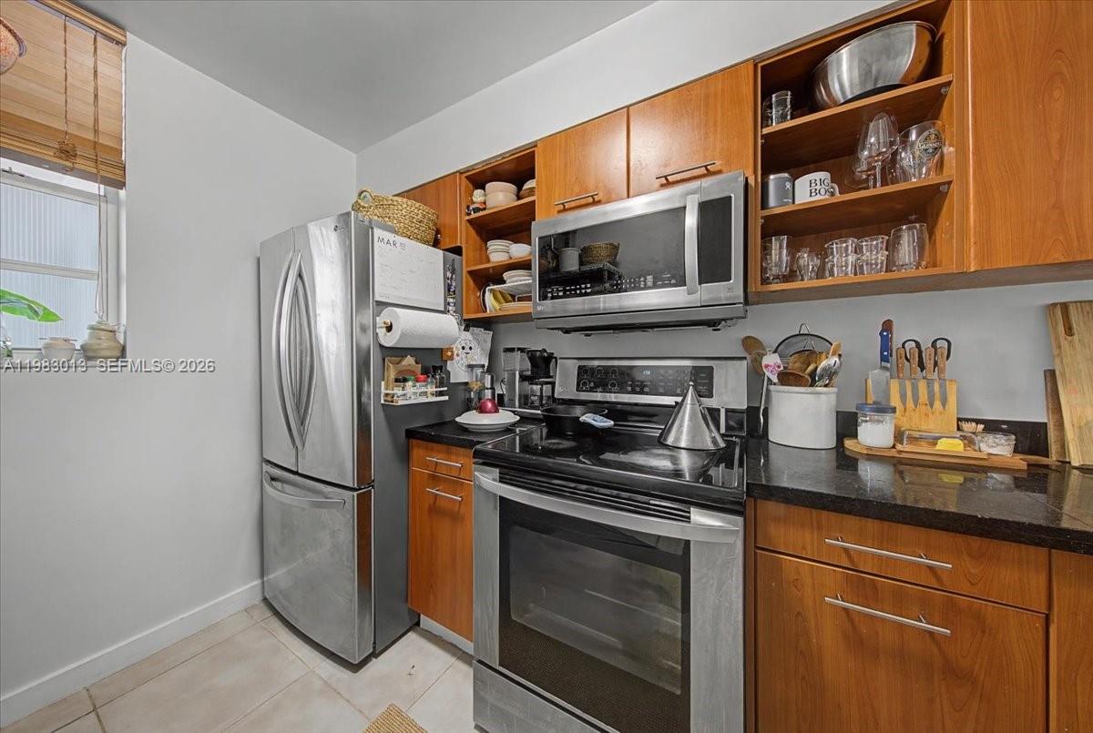 777 Northeast 62nd Street, Unit C211 Miami, FL 33138 - Photo 7 of 22 a kitchen with stainless steel appliances granite countertop a refrigerator a stove a sink and dishwasher