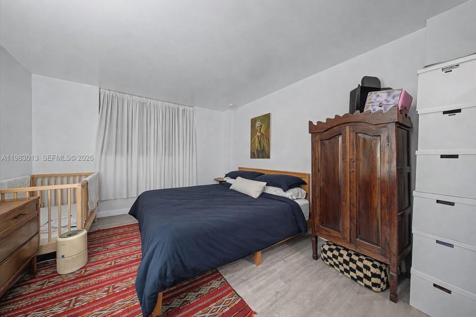777 Northeast 62nd Street, Unit C211 Miami, FL 33138 - Photo 9 of 22 a bedroom with a bed and wooden floor