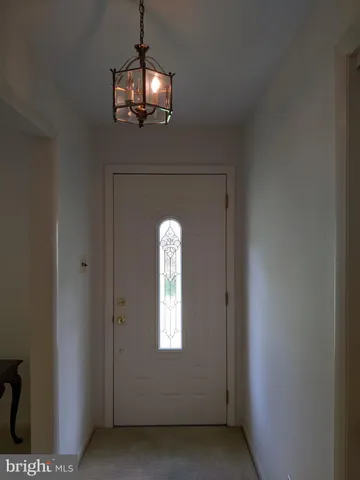 a living room with couches chandelier and a dining table with chandelier
