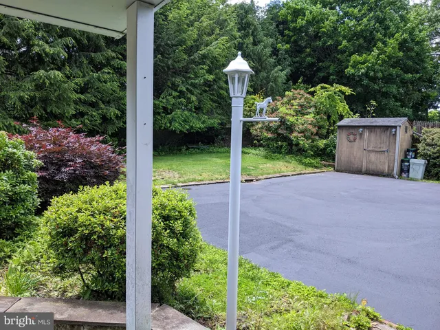 a view of a road with plants and a small yard