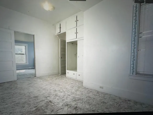an empty room with windows and closet