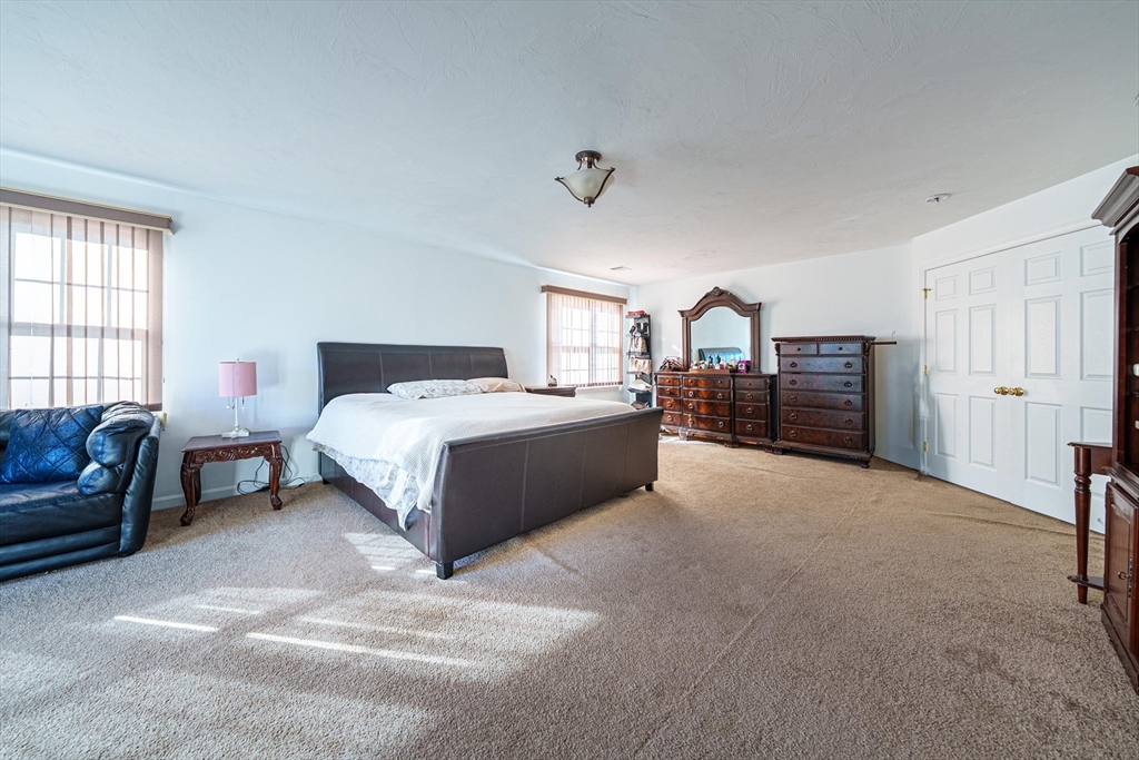 300 Crownshield Avenue Uxbridge, MA 01569 - Photo 14 of 24 a spacious bedroom with a bed a couch and dresser
