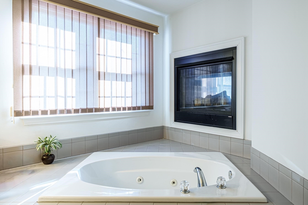 300 Crownshield Avenue Uxbridge, MA 01569 - Photo 16 of 24 a white bath tub sitting in a bathroom next to a window