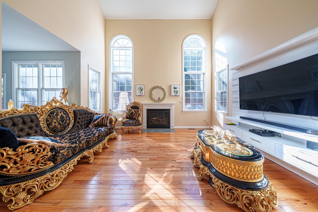300 Crownshield Avenue Uxbridge, MA 01569 - Photo 6 of 24 a living room with furniture a flat screen tv and a fireplace