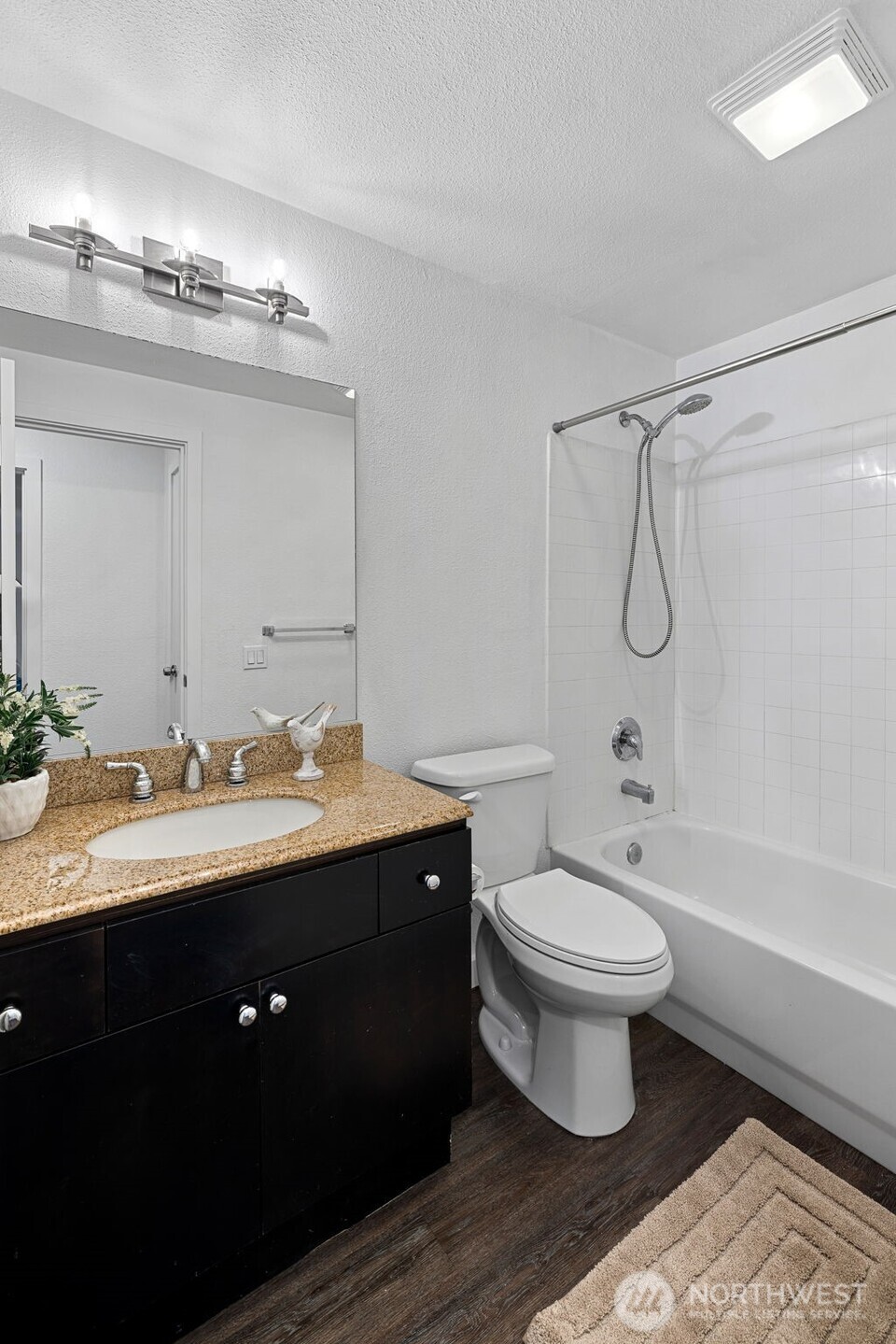 9806 28th Avenue Southwest, Unit A104 Seattle, WA 98126 - Photo 11 of 25 a bathroom with a double vanity sink toilet mirror and bathtub