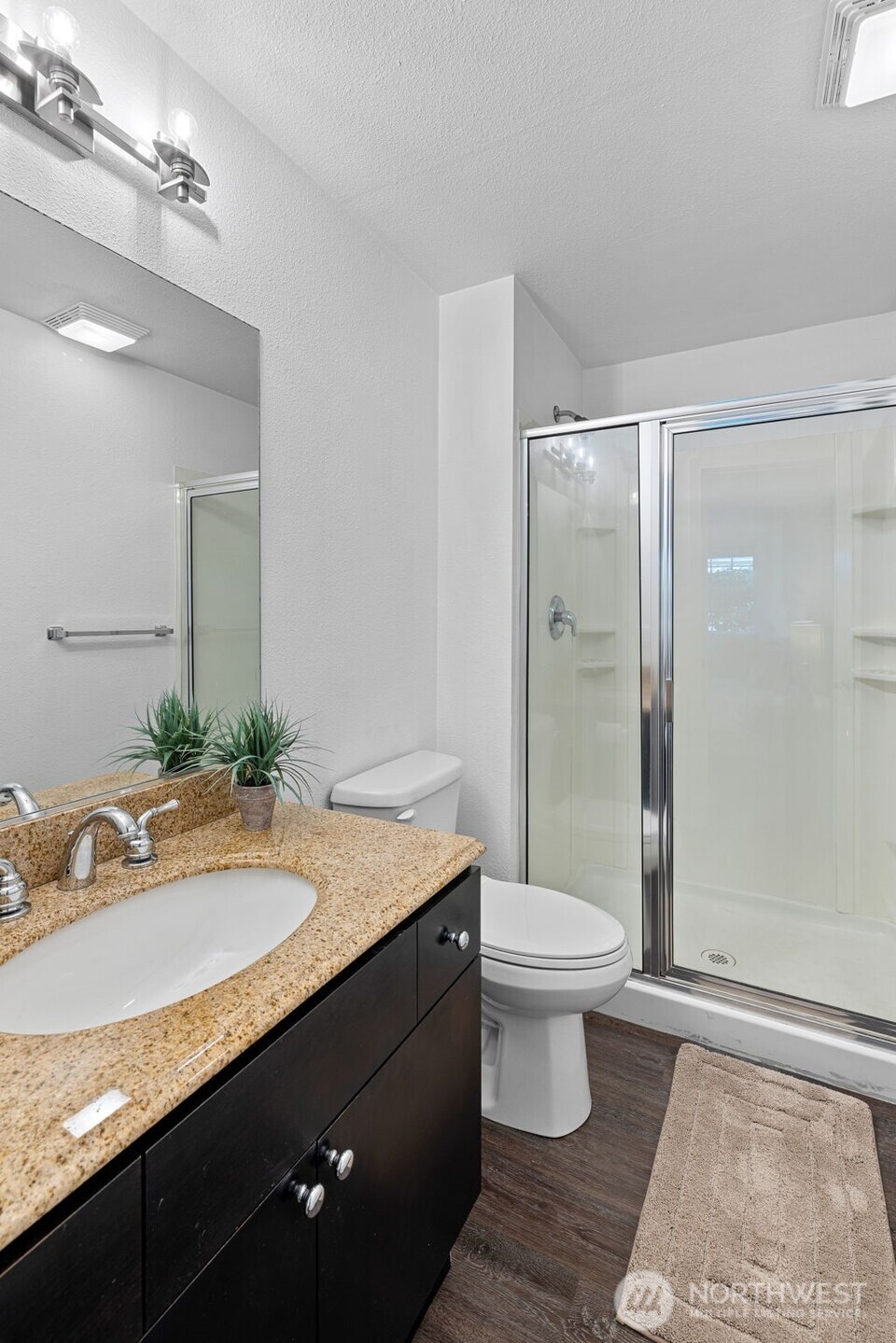 9806 28th Avenue Southwest, Unit A104 Seattle, WA 98126 - Photo 16 of 25 a bathroom with a sink a toilet a mirror and shower