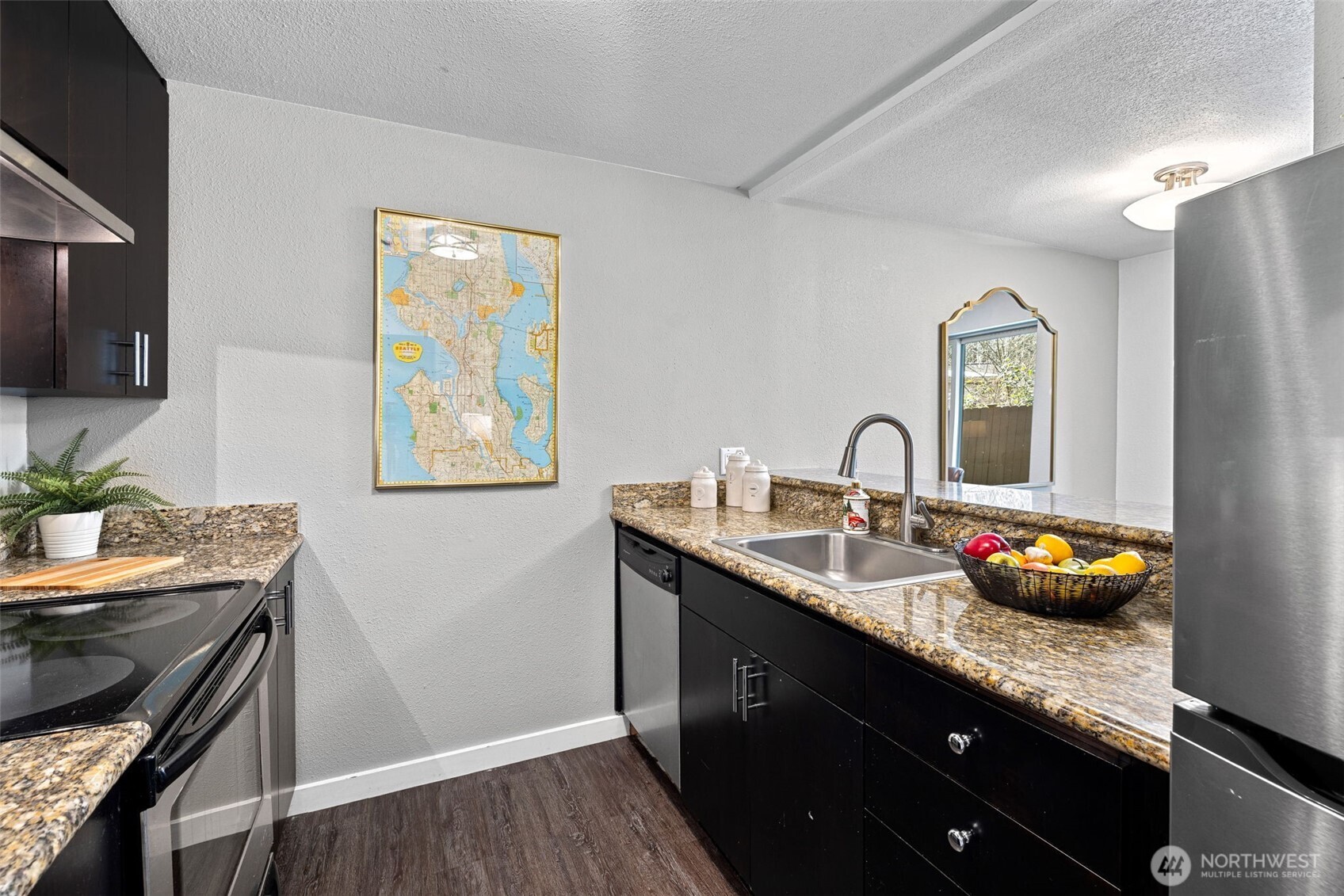 9806 28th Avenue Southwest, Unit A104 Seattle, WA 98126 - Photo 8 of 25 a kitchen with stainless steel appliances a sink stove and cabinets