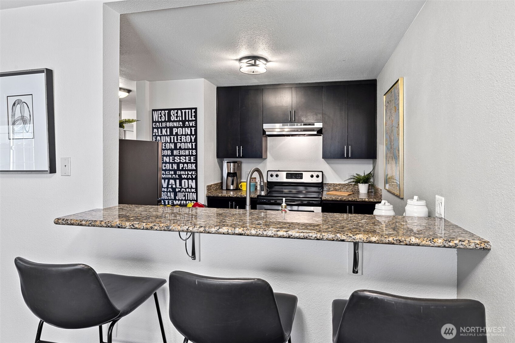 9806 28th Avenue Southwest, Unit A104 Seattle, WA 98126 - Photo 10 of 25 a dining room with kitchen island granite countertop furniture a rug and stainless steel appliances