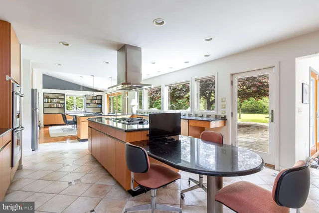 a dining room with furniture a large window and a chandelier