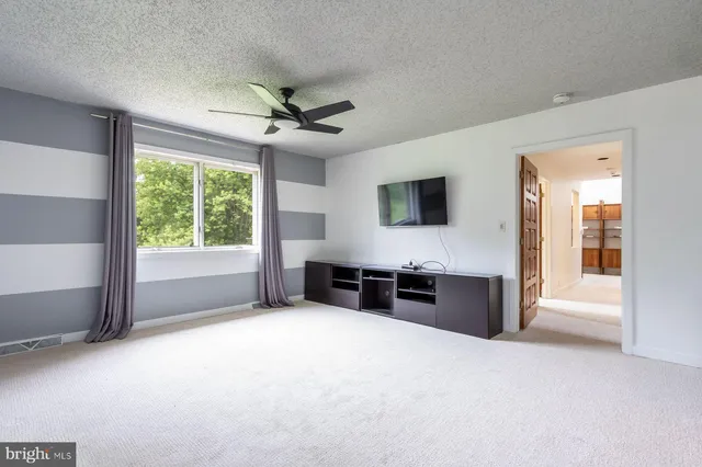 a view of a big room with windows cabinet and a living room