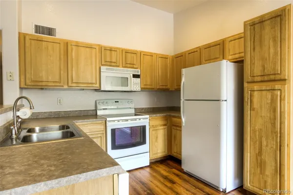 a kitchen with stainless steel appliances granite countertop a refrigerator sink and stove