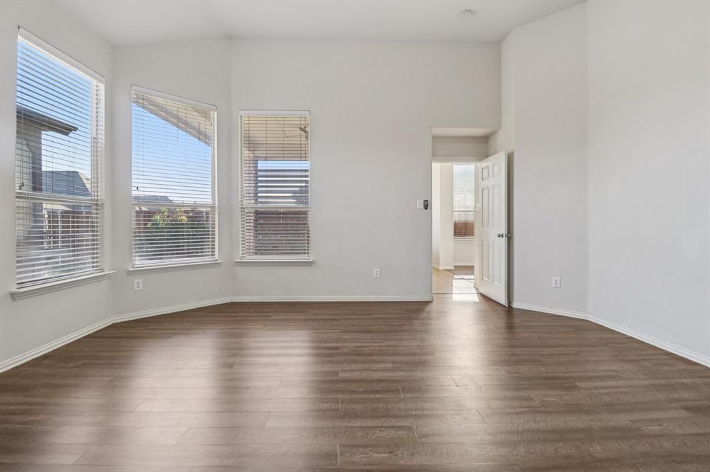 588 Louder Way Fate, TX 75087 - Photo 19 of 34 Unfurnished room with plenty of natural light, dark wood finished floors, and lofted ceiling