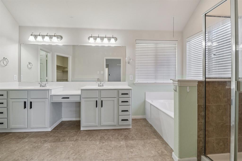 588 Louder Way Fate, TX 75087 - Photo 20 of 34 Full bath with a garden tub, double vanity, a shower stall, vaulted ceiling, and light tile patterned floors