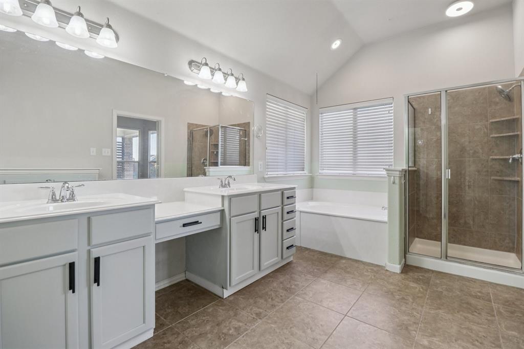 588 Louder Way Fate, TX 75087 - Photo 22 of 34 Full bath featuring a garden tub, lofted ceiling, double vanity, a stall shower, and plenty of natural light