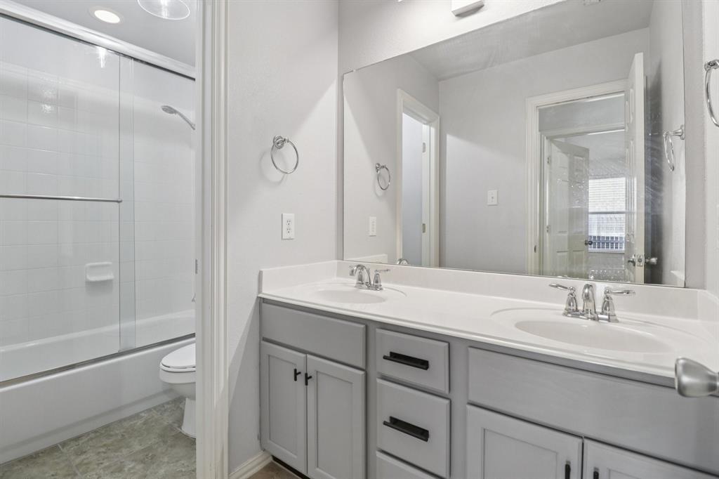 588 Louder Way Fate, TX 75087 - Photo 23 of 34 Full bath featuring double vanity and enclosed tub / shower combo