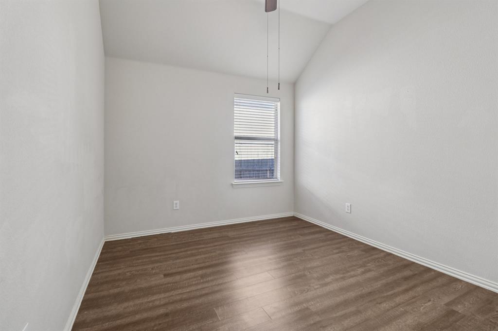 588 Louder Way Fate, TX 75087 - Photo 25 of 34 Unfurnished room featuring vaulted ceiling and dark wood-style flooring