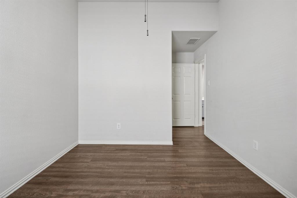 588 Louder Way Fate, TX 75087 - Photo 26 of 34 Empty room with dark wood finished floors