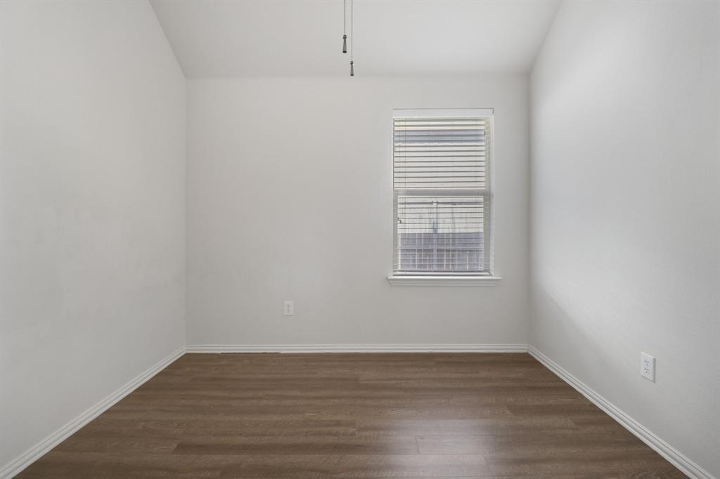 588 Louder Way Fate, TX 75087 - Photo 27 of 34 Empty room with dark wood-type flooring and vaulted ceiling