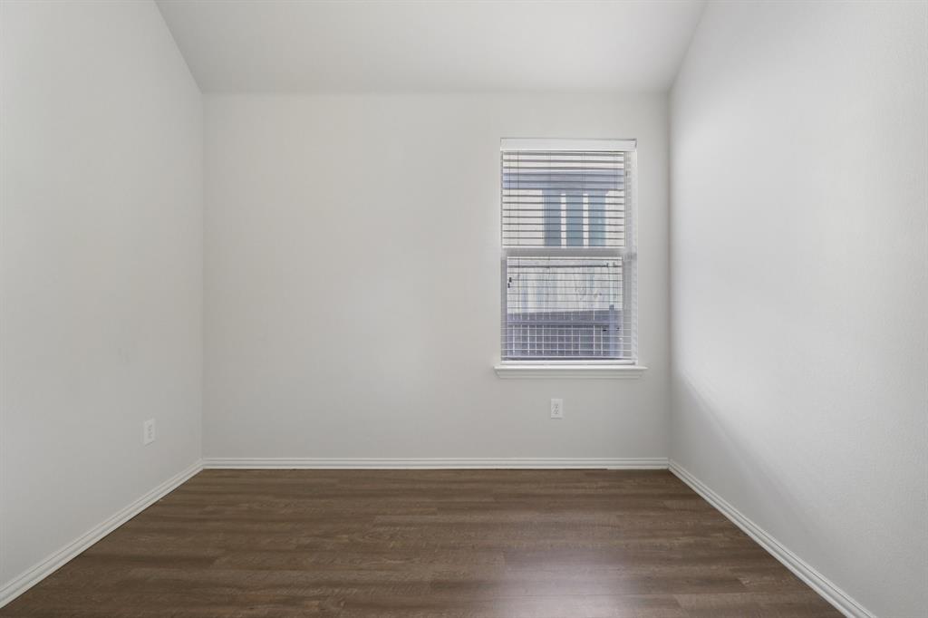 588 Louder Way Fate, TX 75087 - Photo 29 of 34 Empty room with dark wood-style floors and lofted ceiling