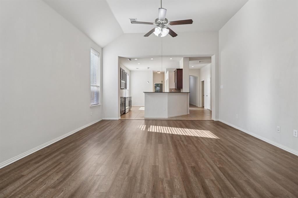 588 Louder Way Fate, TX 75087 - Photo 7 of 34 Unfurnished living room with lofted ceiling, dark wood-style flooring, a ceiling fan, and recessed lighting