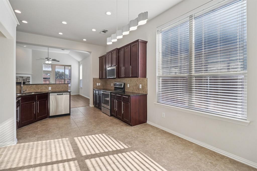 588 Louder Way Fate, TX 75087 - Photo 8 of 34 Kitchen featuring tasteful backsplash, stainless steel appliances, dark brown cabinetry, recessed lighting, and lofted ceiling