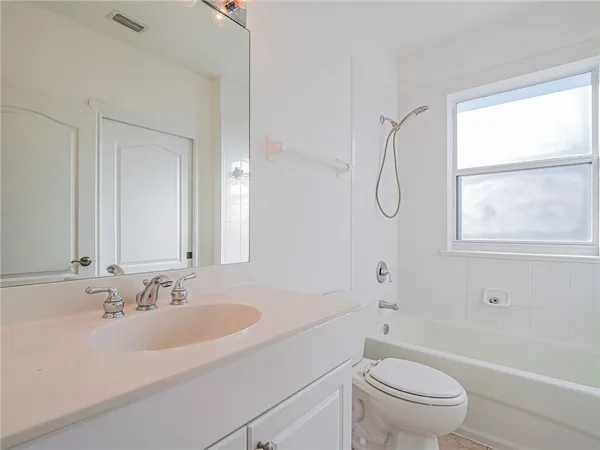 a bathroom with a sink toilet vanity and tub