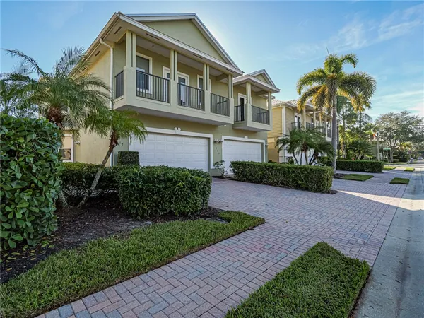 a front view of a house with a yard and potted plants