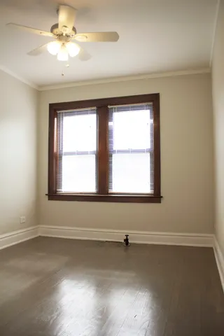 an empty room with a window and a ceiling fan