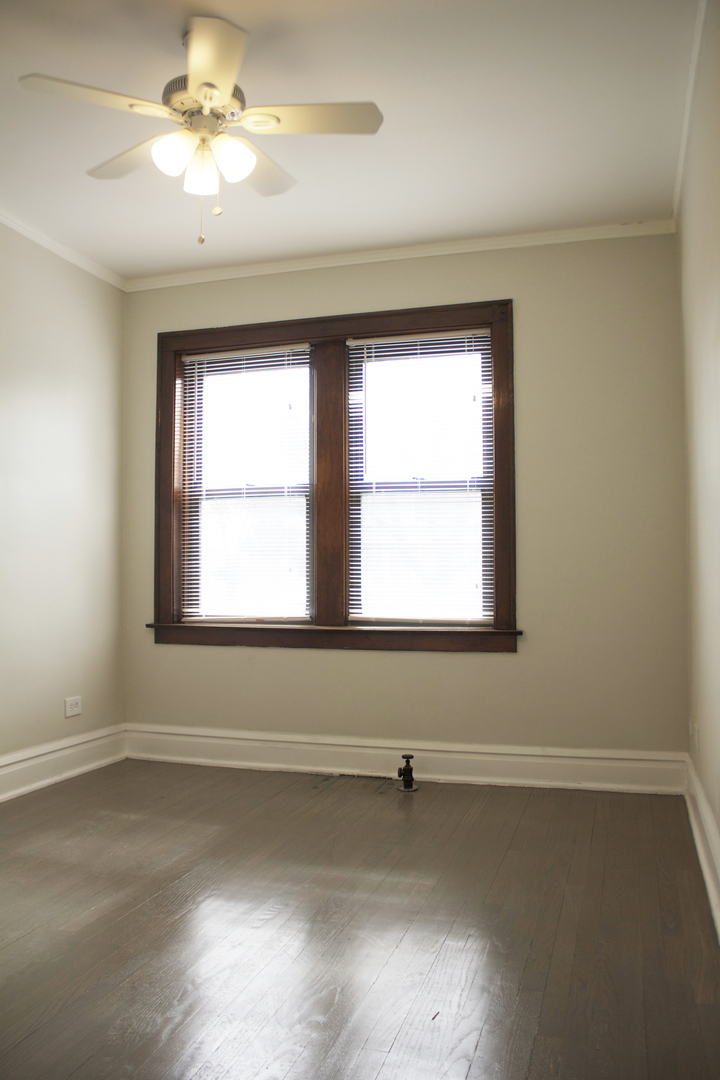 6 West 111th Place Chicago, IL 60628 - Photo 12 of 18 an empty room with a window and a ceiling fan