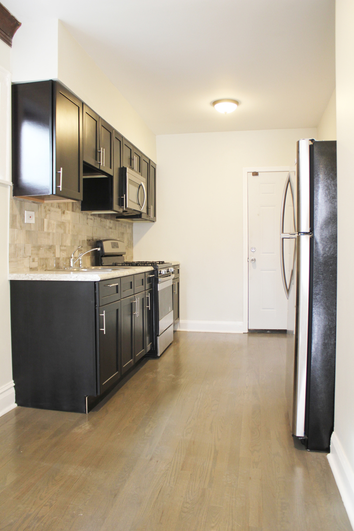 6 West 111th Place Chicago, IL 60628 - Photo 3 of 18 a kitchen with stainless steel appliances a sink and a refrigerator