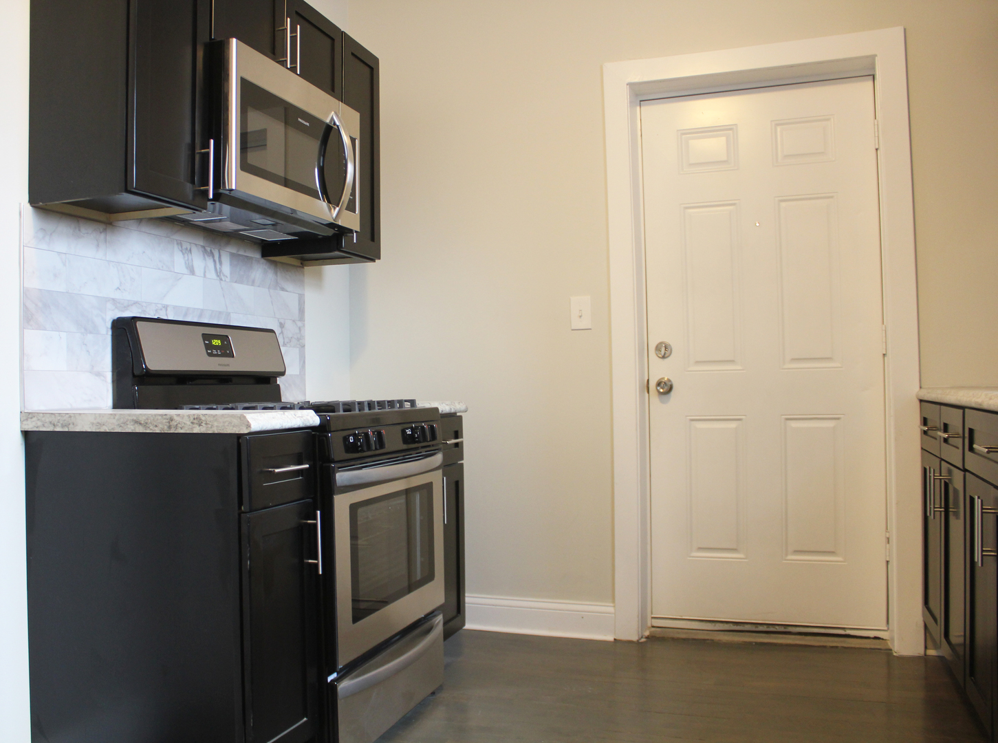 6 West 111th Place Chicago, IL 60628 - Photo 4 of 18 a kitchen with stainless steel appliances granite countertop white cabinets and a stove top oven
