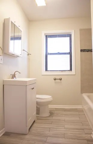 a bathroom with a sink toilet and window