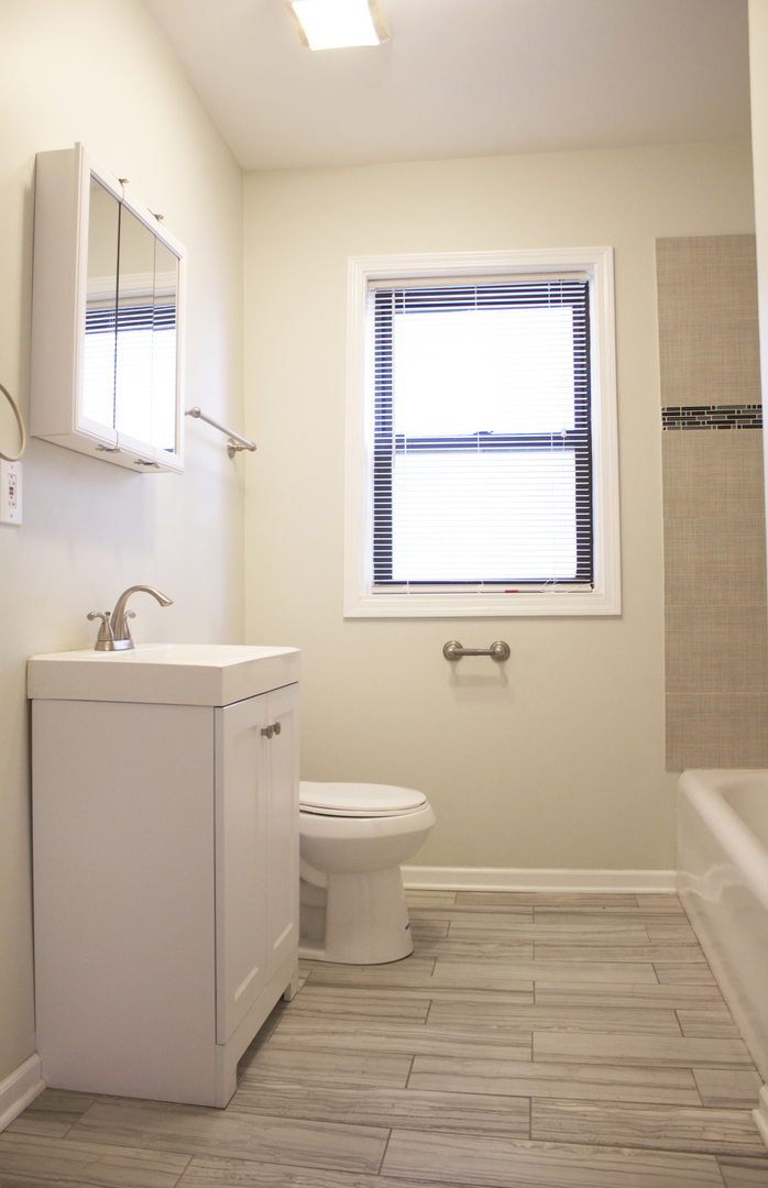 6 West 111th Place Chicago, IL 60628 - Photo 6 of 18 a bathroom with a sink toilet and window