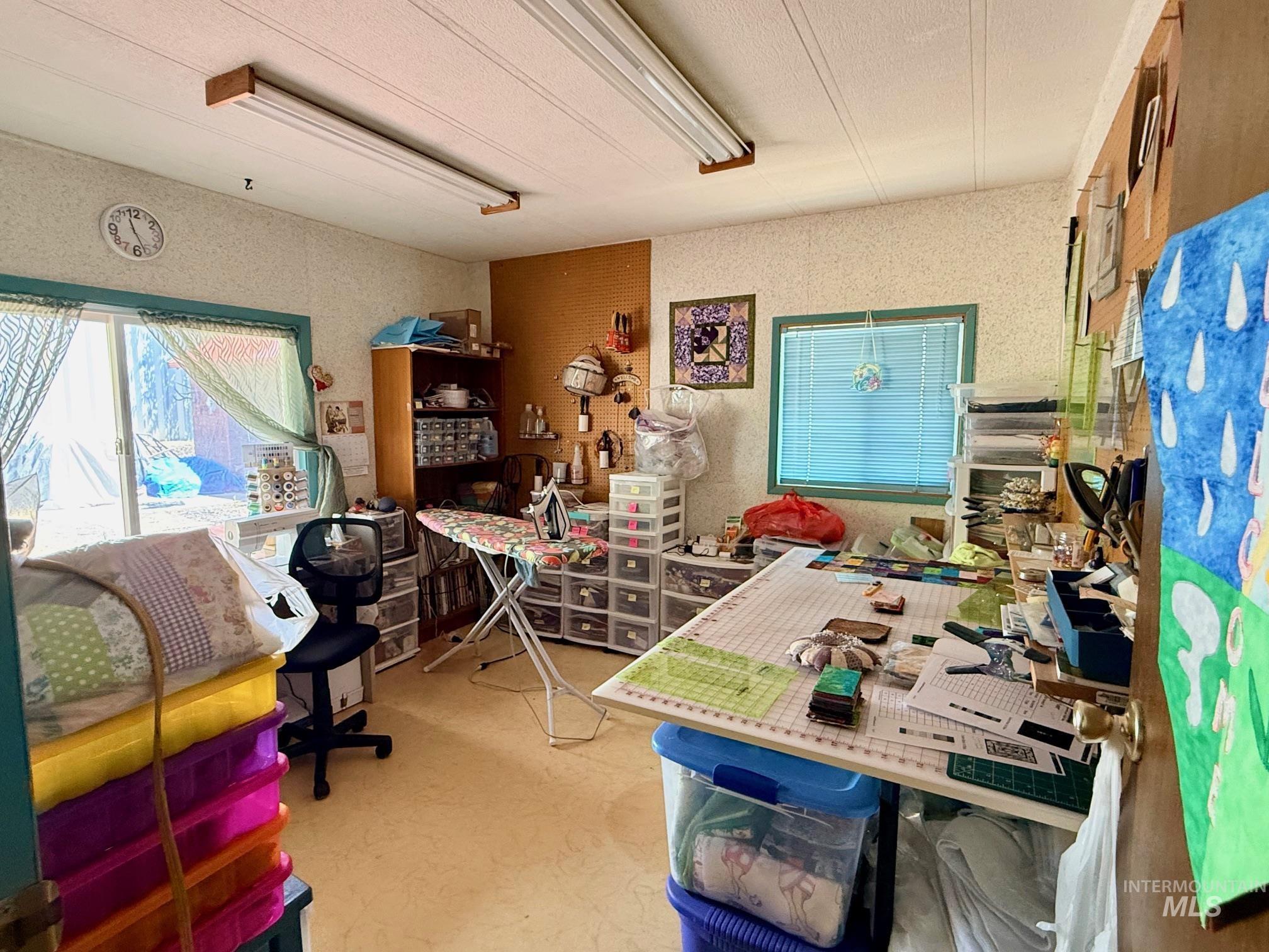35322 River Road Lenore, ID 83541 - Photo 21 of 42 Versatile interior space featuring light-toned flooring, two windows with blinds, a sliding glass door, and overhead fluorescent lighting fixtures