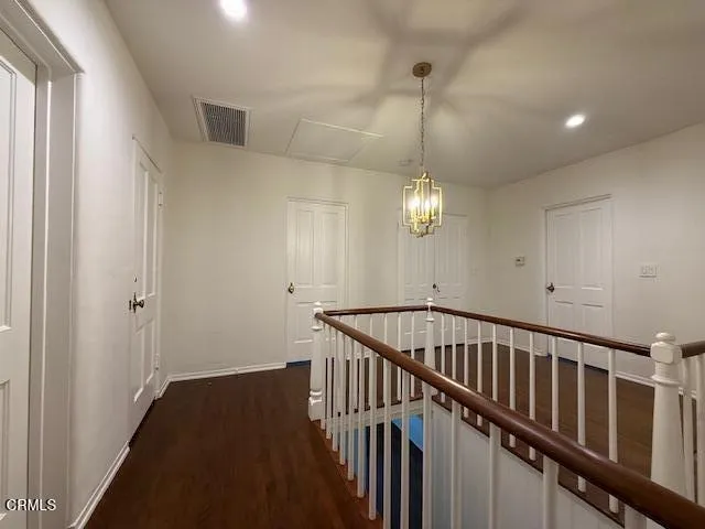 a view of an empty room with wooden floor and closet