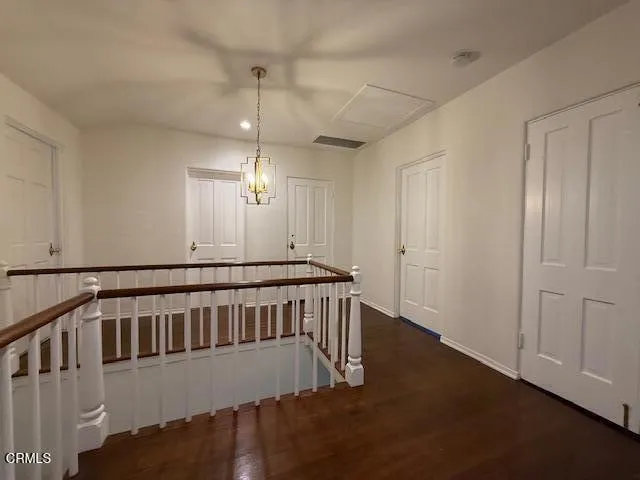 a view of an empty room with wooden floor and windows