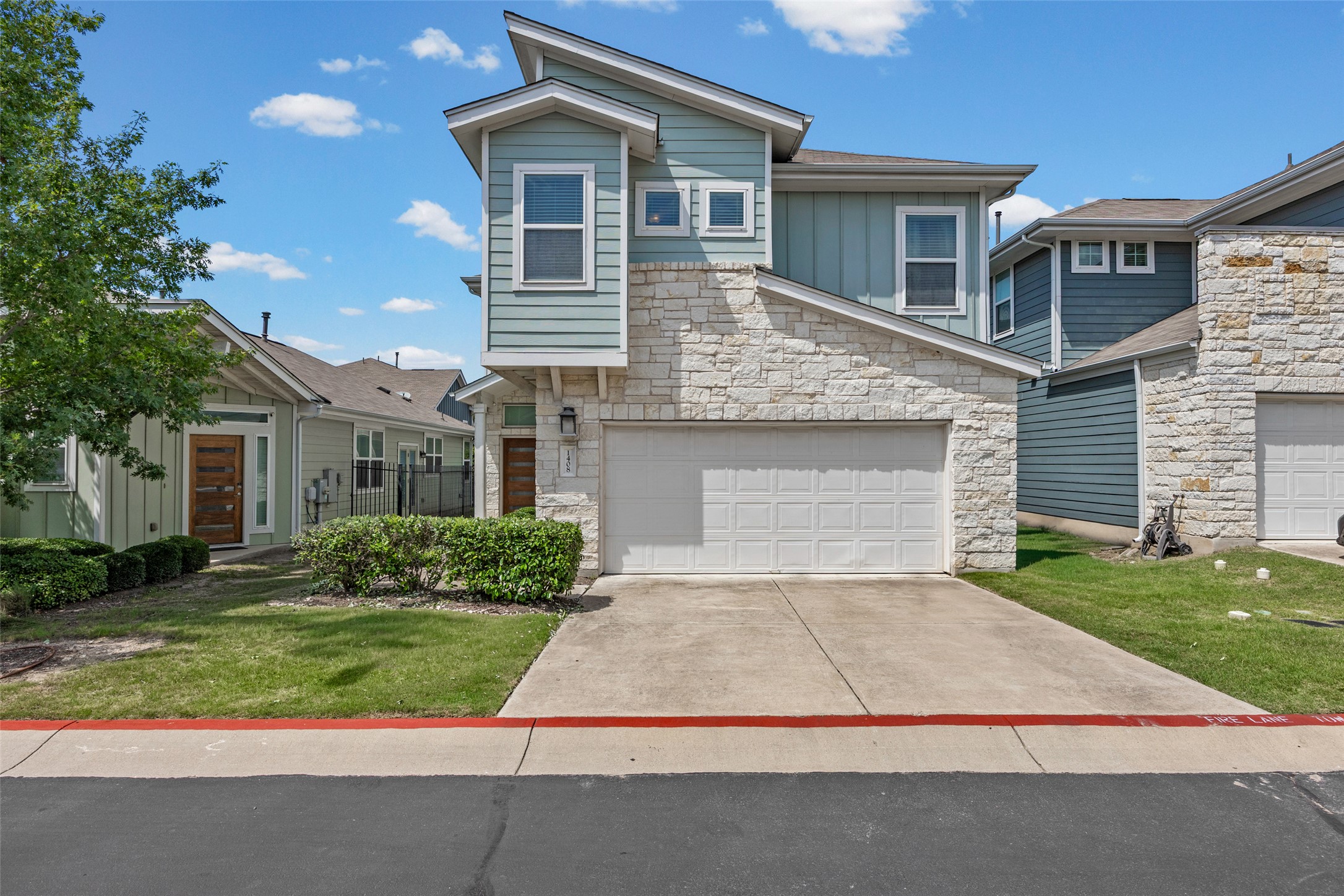 1408 Homespun Road Austin, TX 78745 - Photo 1 of 20 Modern townhome boasts stone and siding, a front entry garage, and a neatly manicured lawn.